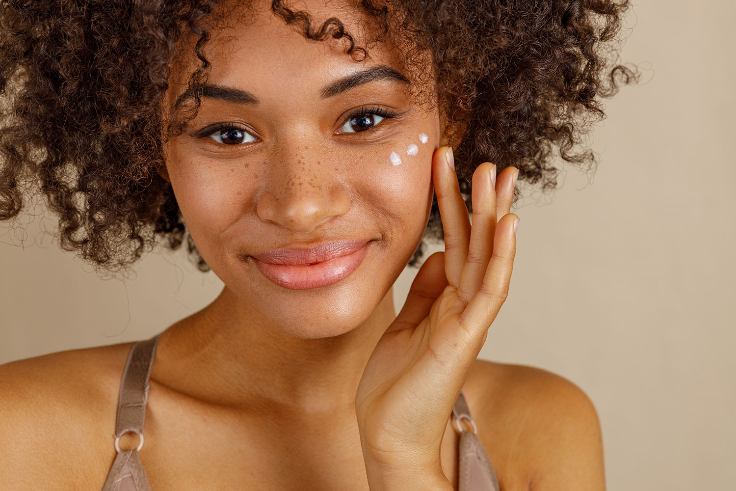 Beautiful woman applying skin care cream